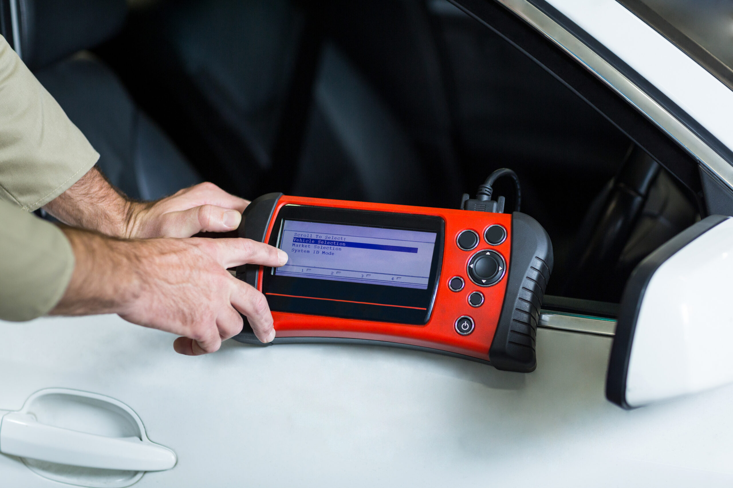 Hands of mechanic using a diagnostic tool Hands of mechanic using a diagnostic tool in repair garage