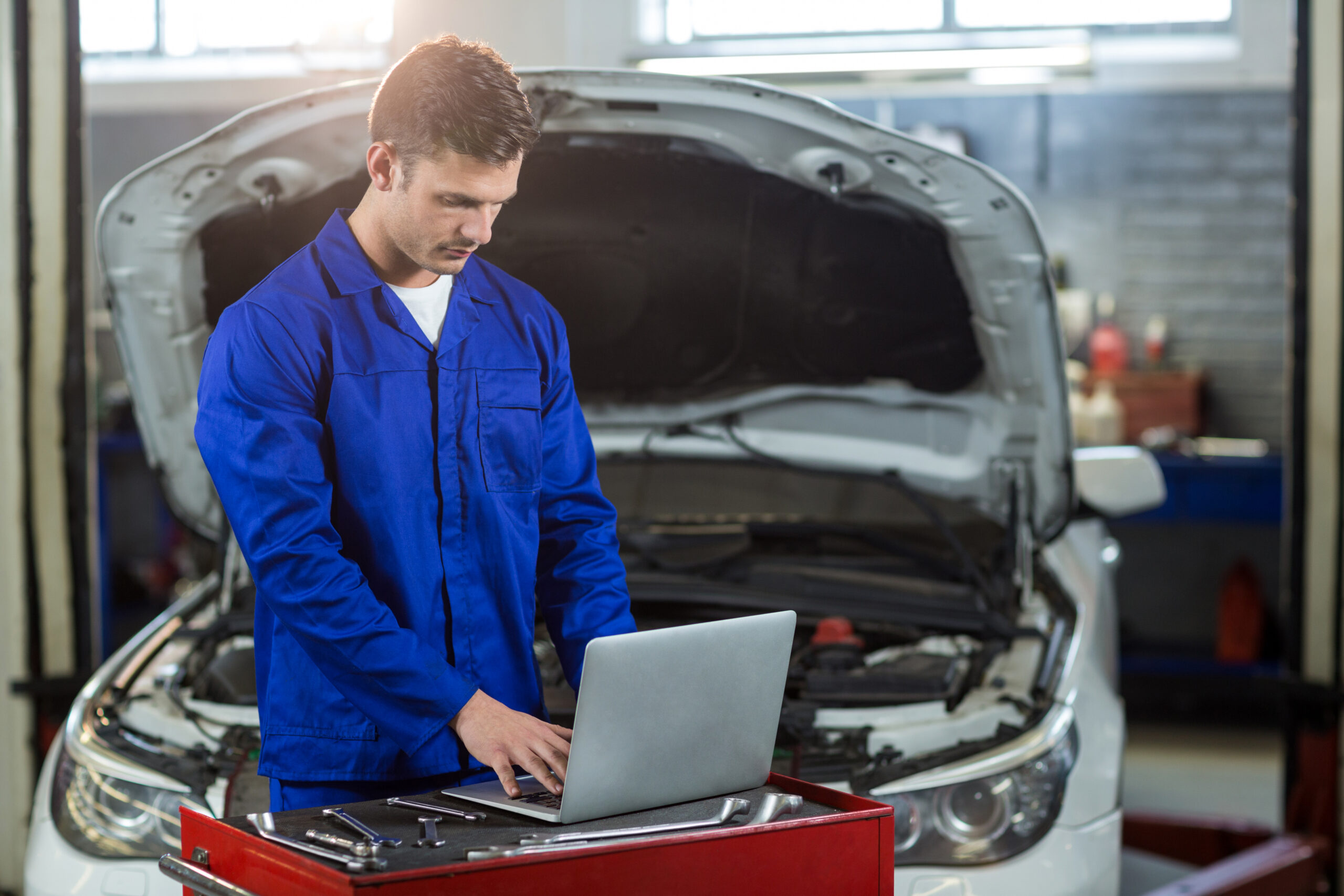 Mechanic using laptop Mechanic using laptop in repair garage